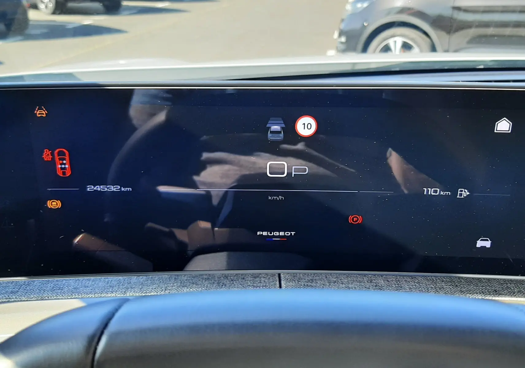 Vue intérieure du tableau de bord numérique du Peugeot 3008 Hybrid 2024, avec affichage digital et volant en premier plan.