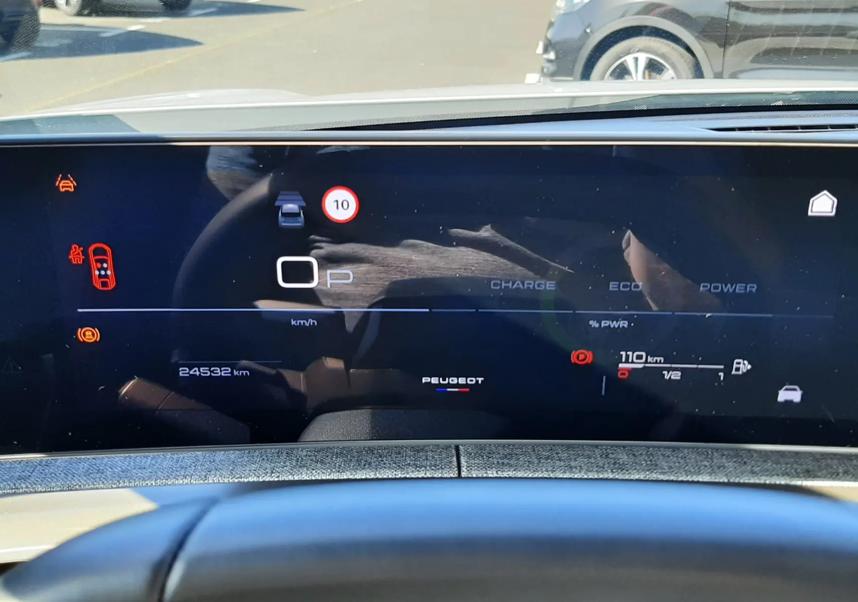 Vue intérieure du tableau de bord numérique du Peugeot 3008 hybride blanc, affichant la vitesse, autonomie et indicateurs de conduite.