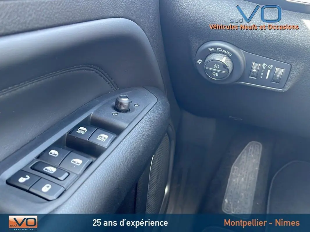 Gros plan sur les commandes de vitres et réglages des rétroviseurs côté conducteur du Jeep Compass noir 2023.