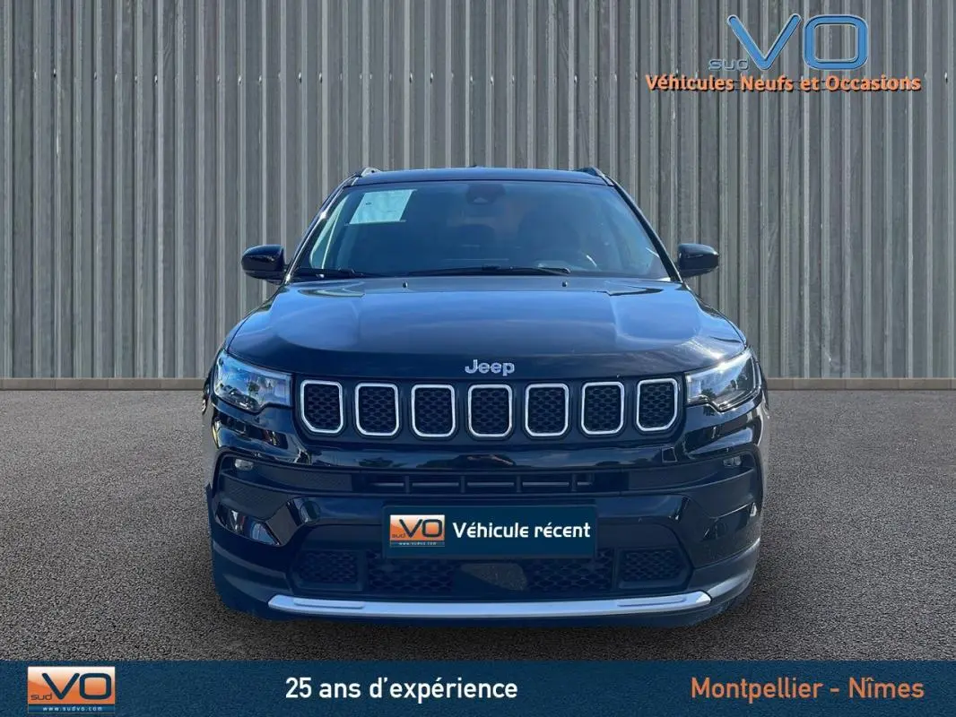 Vue frontale d'un Jeep Compass noir 2023 avec calandre distinctive et barres de toit visibles sur fond neutre.