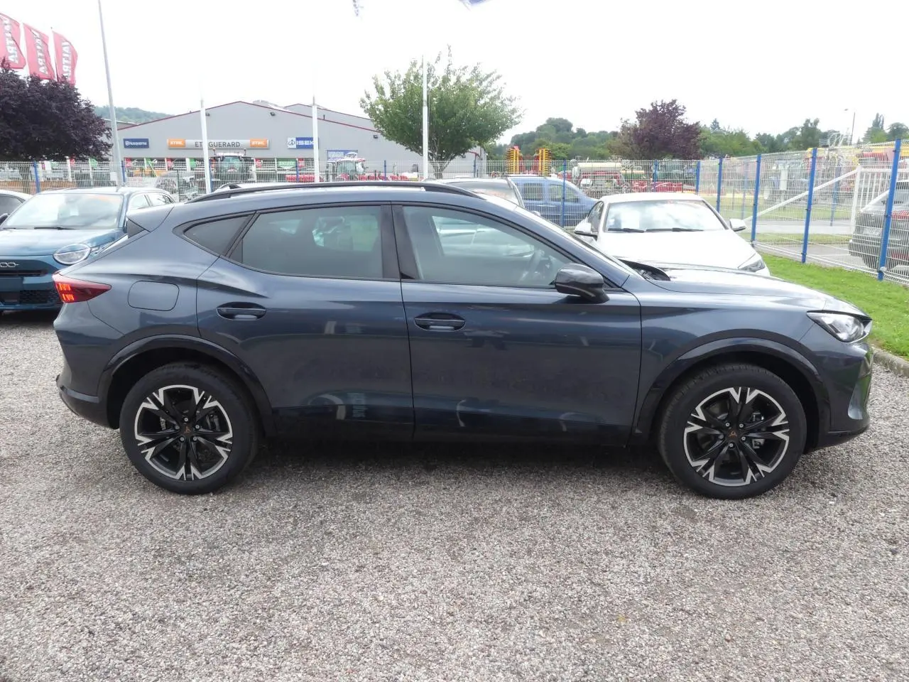 Profil côté gauche du SUV CUPRA Formentor gris Graphene avec jantes alliage noires et toit panoramique visible