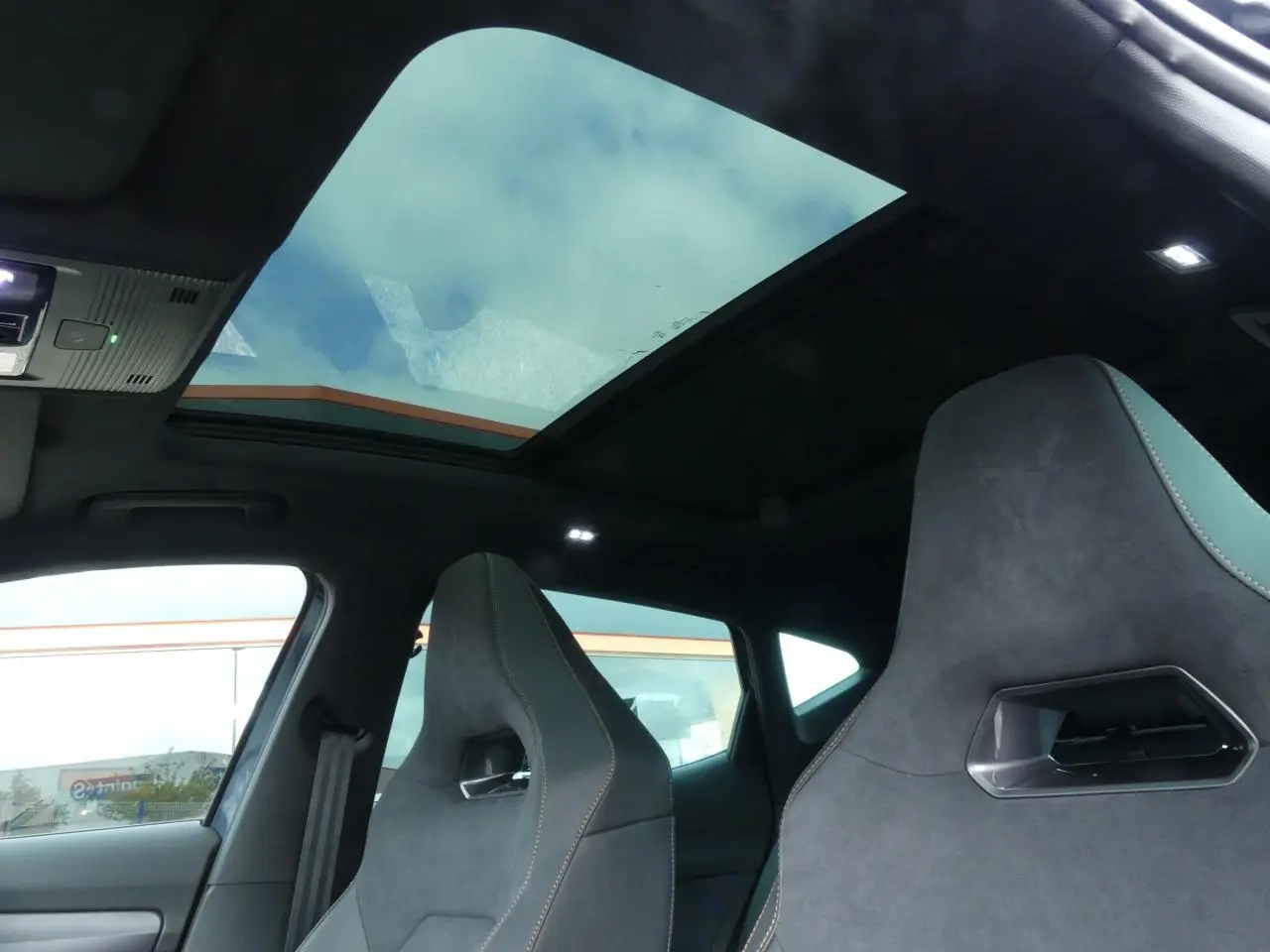 Intérieur du CUPRA Formentor gris Graphene, vue sur sièges baquets suédine noirs avec surpiqûres cuivrées et toit ouvrant panoramique.