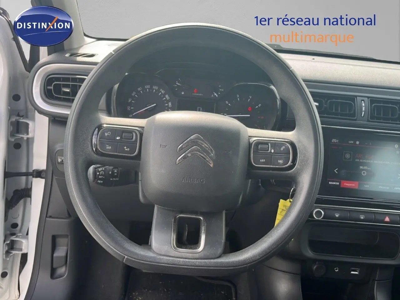 Vue intérieure centrée sur le volant de la Citroën C3 blanche de 2018, avec tableau de bord et écran tactile visibles.