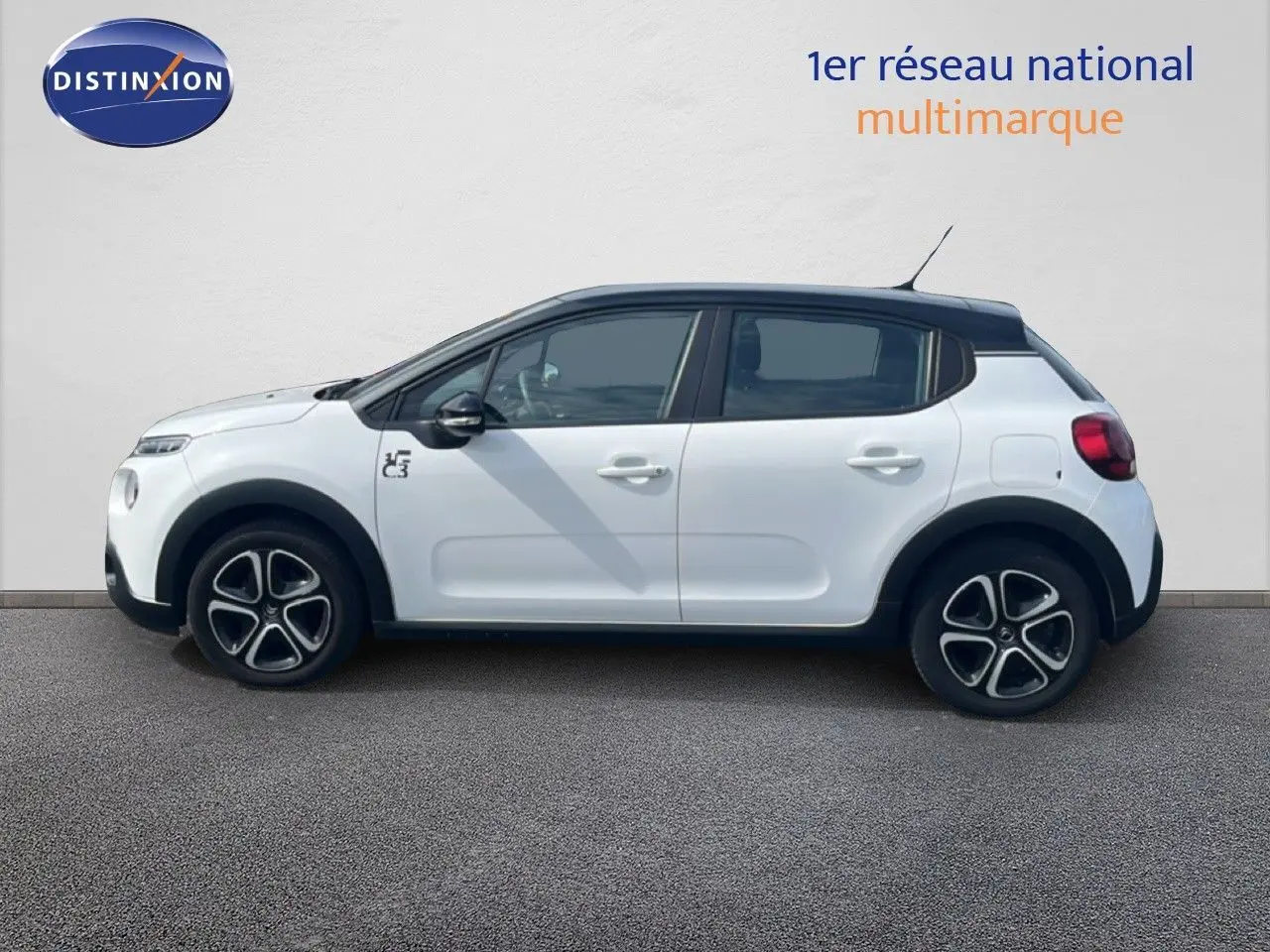 Profil côté gauche d'une Citroën C3 blanche 2018 avec toit noir et jantes distinctives à cinq branches.