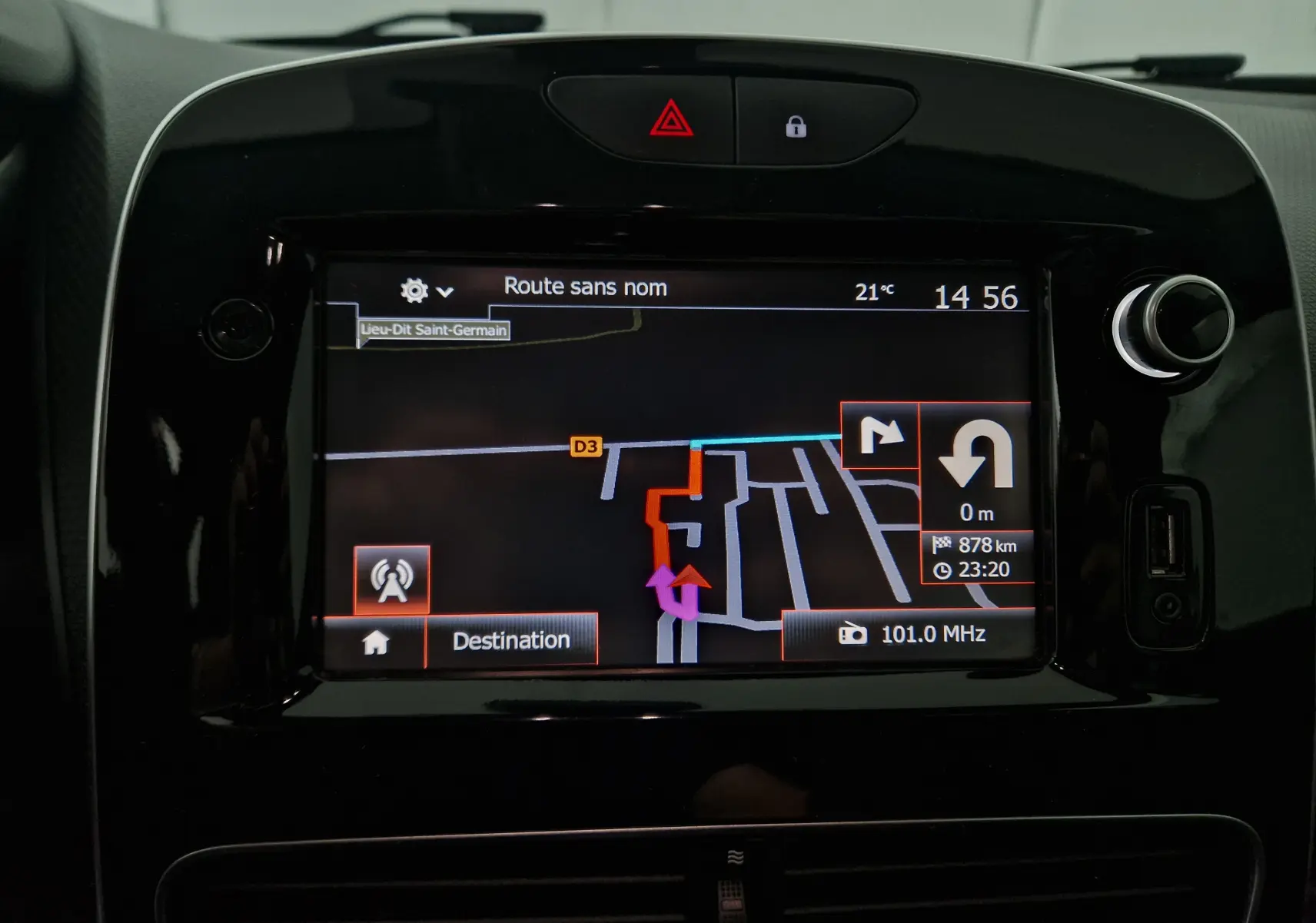 Écran tactile central noir du tableau de bord de la Renault Clio IV gris clair, affichant la navigation GPS en mode jour.
