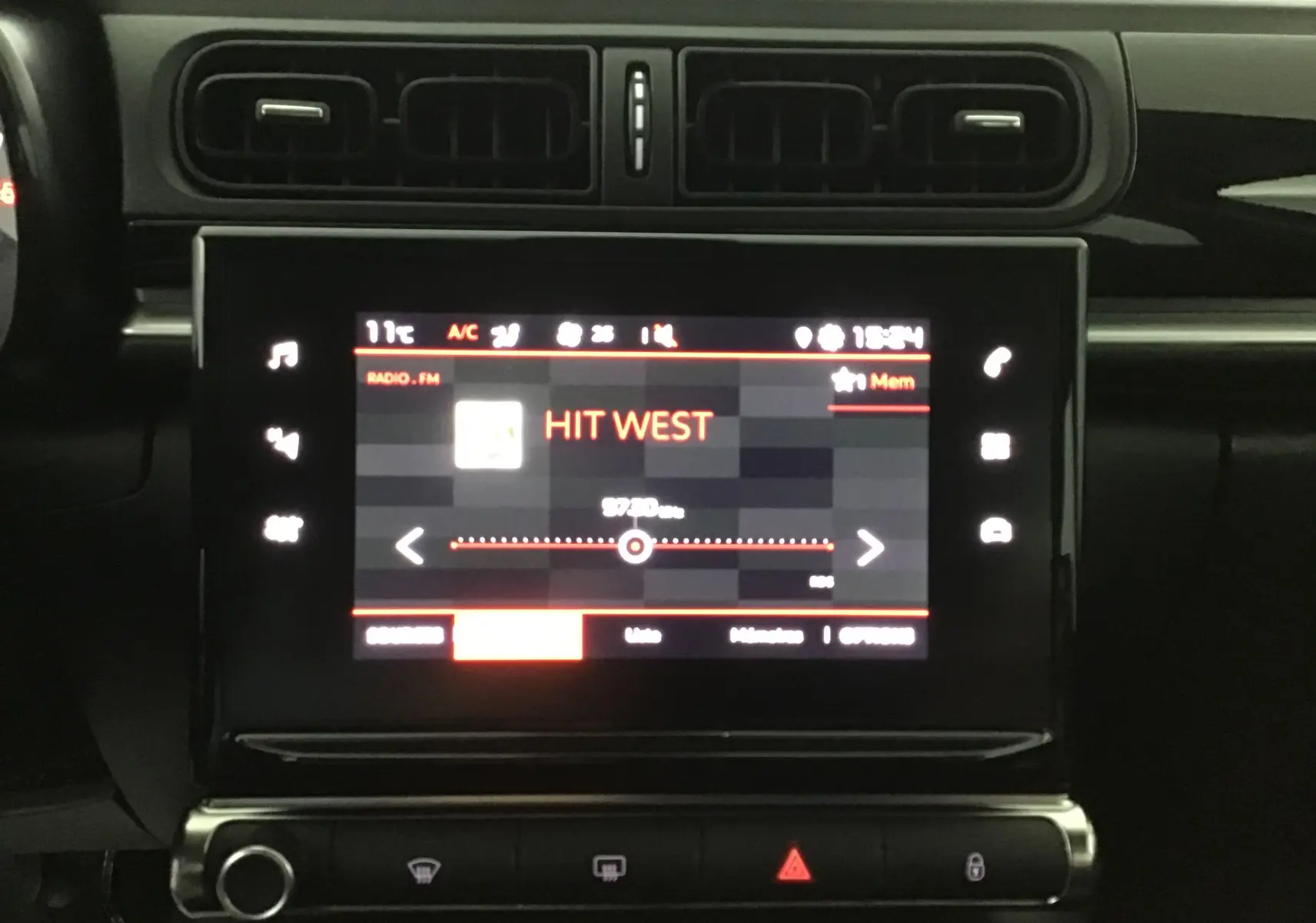 Vue rapprochée de l’écran tactile central du tableau de bord de la Citroën C3 2022, affichant la radio FM sur Hit West.