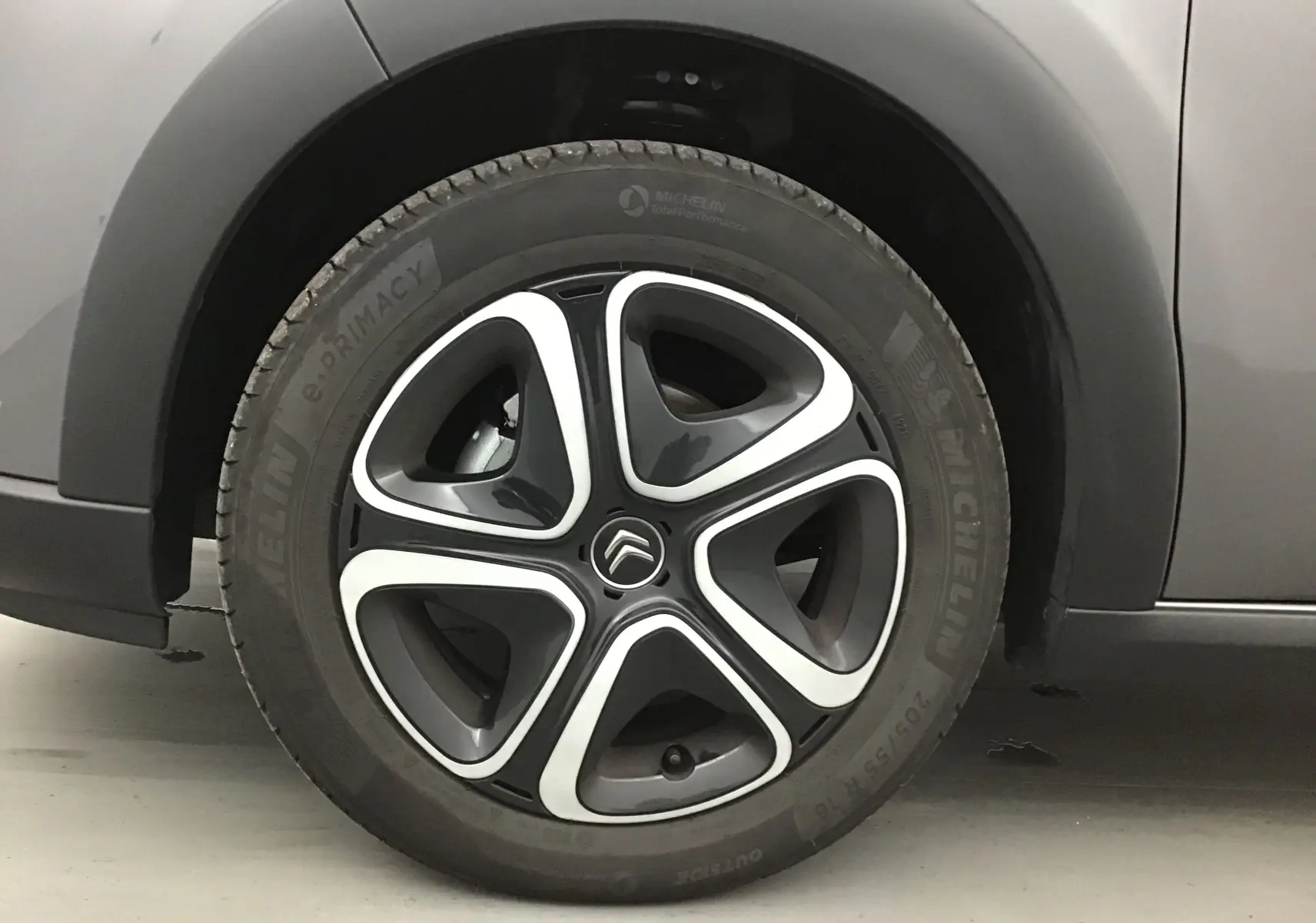 Gros plan sur la roue arrière droite d'une Citroën C3 gris platinium avec passage de roue noir mat.
