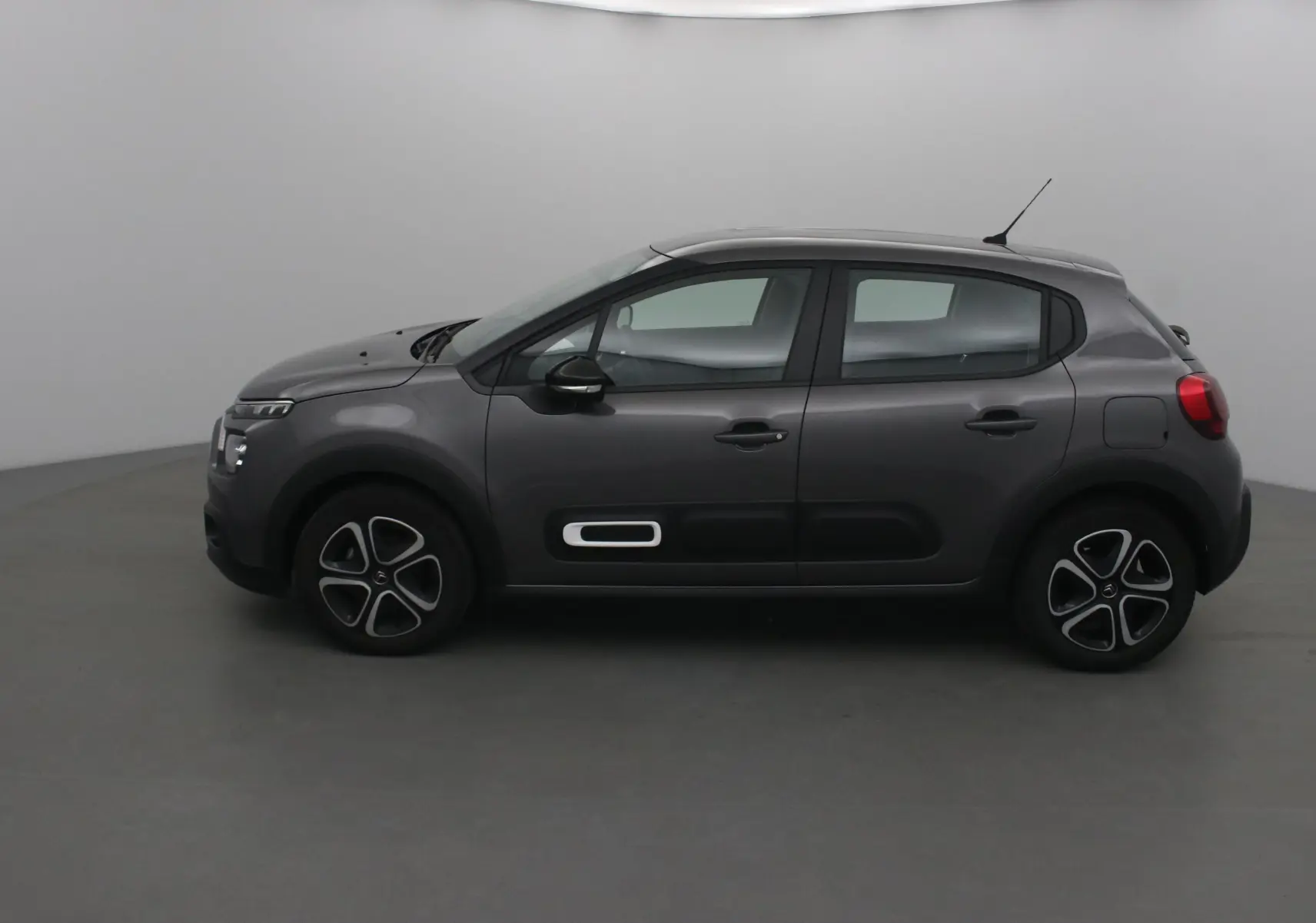 Profil droit d'une Citroën C3 gris platinium 2022 avec protections latérales noires et jantes distinctives.
