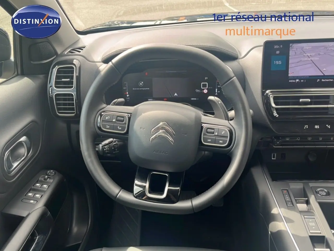 Vue intérieure centrée sur le volant et tableau de bord du Citroën C5 Aircross noir métal, avec écran tactile et commandes au volant.
