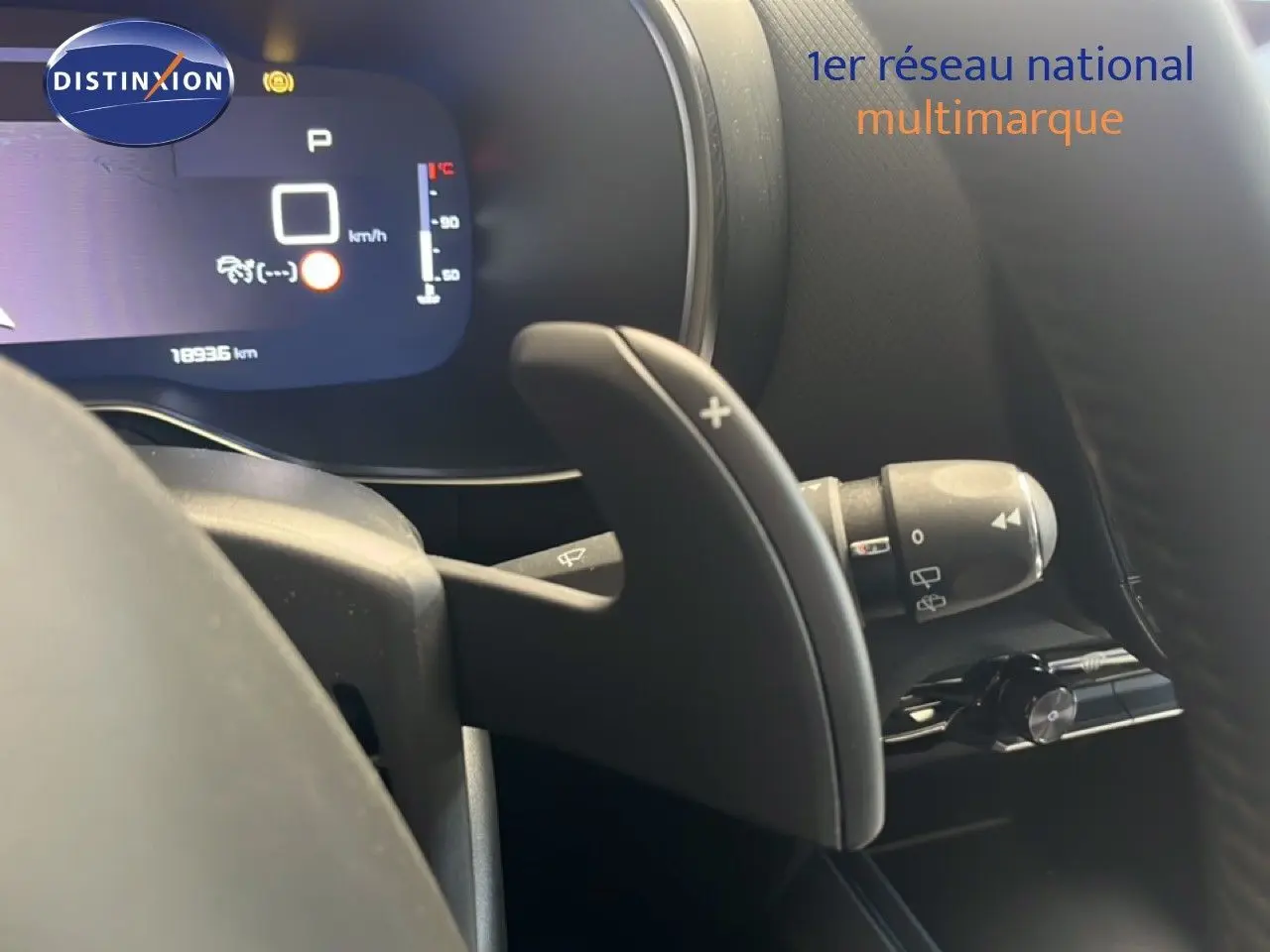 Gros plan sur la palette de changement de vitesse droite et le tableau de bord numérique d’un Citroën C5 Aircross noir métal.