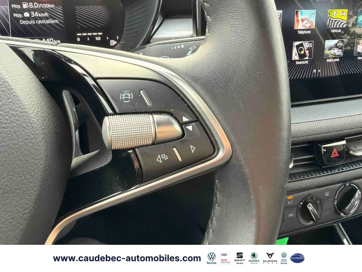 Gros plan sur le volant cuir multifonctions et la console centrale avec écran tactile du Skoda Fabia noir 2025.