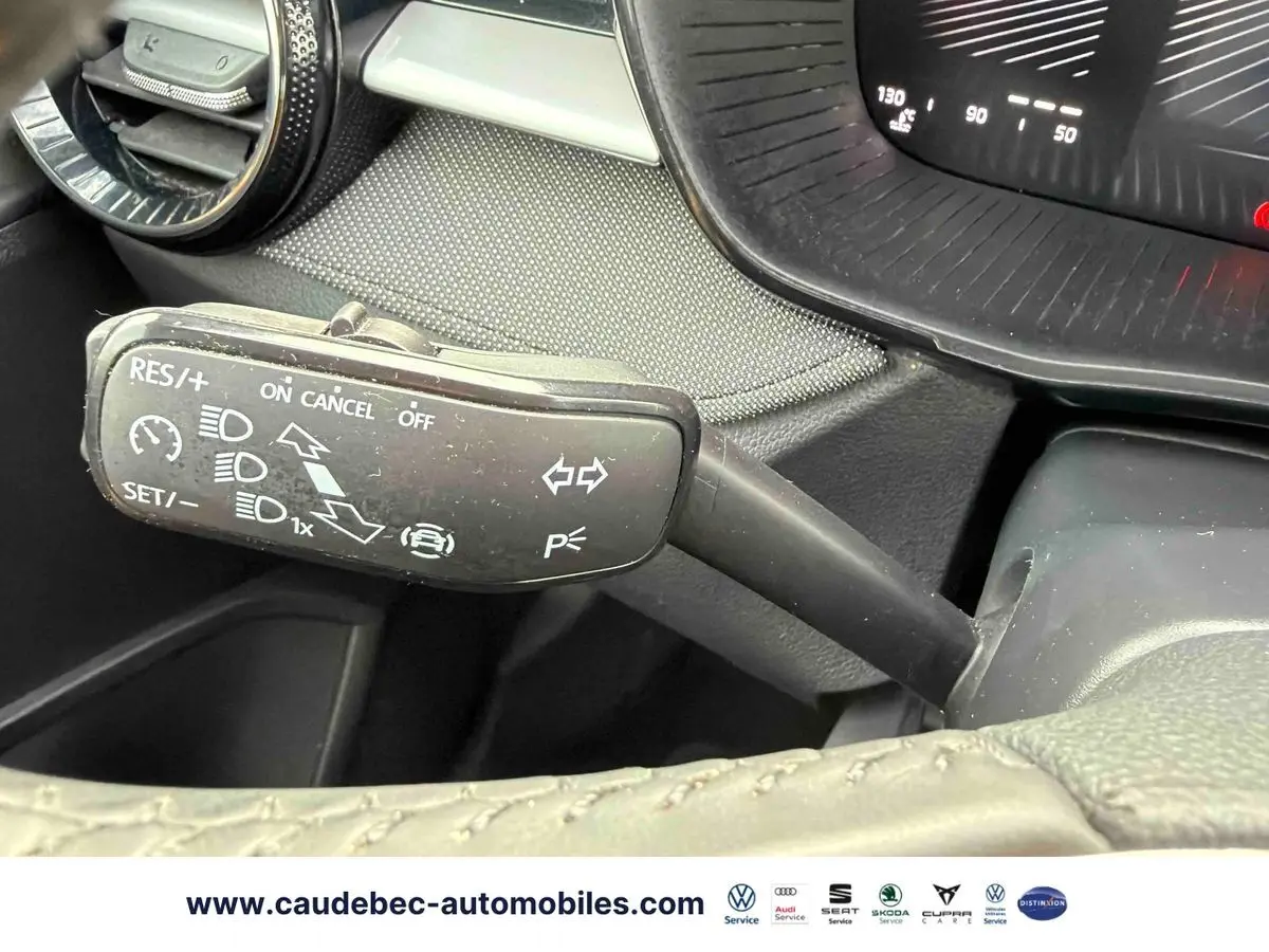 Gros plan sur la commande multifonction noire à gauche du volant dans l’habitacle d’une Skoda Fabia noire.