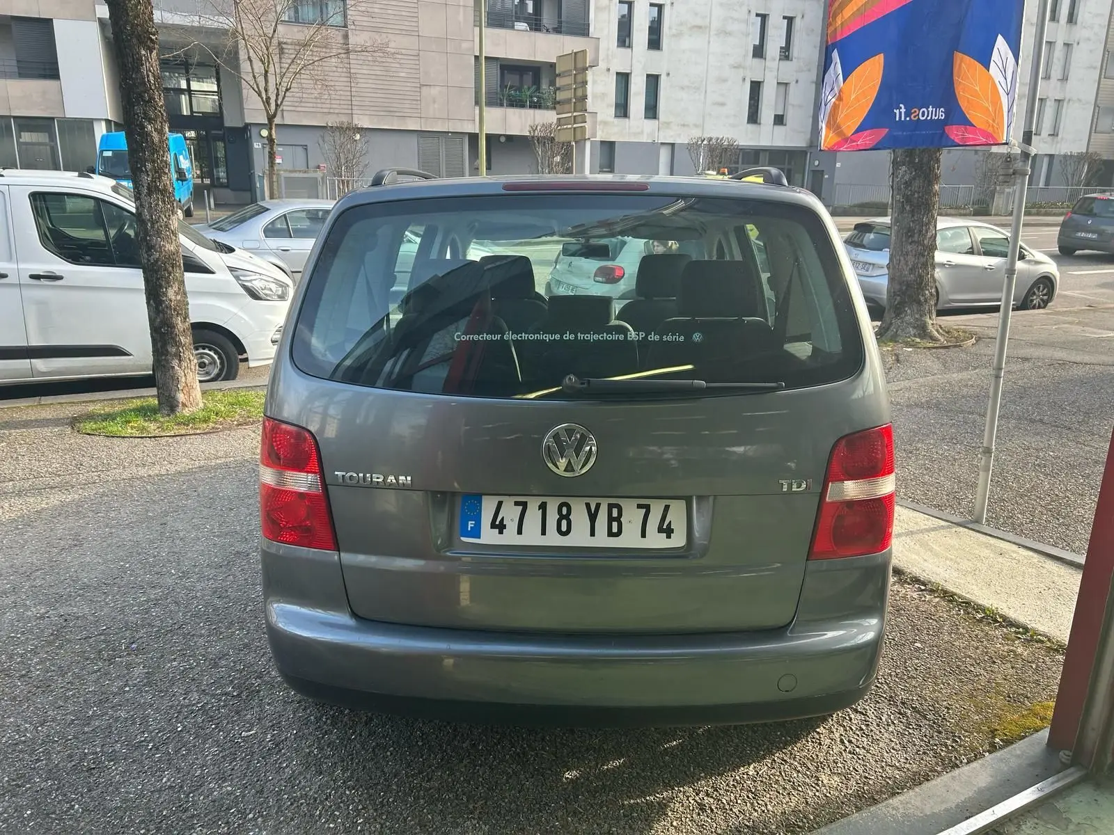 Vue arrière d'un Volkswagen Touran gris 2004 avec plaques françaises, feux rouges et hayon vitré.