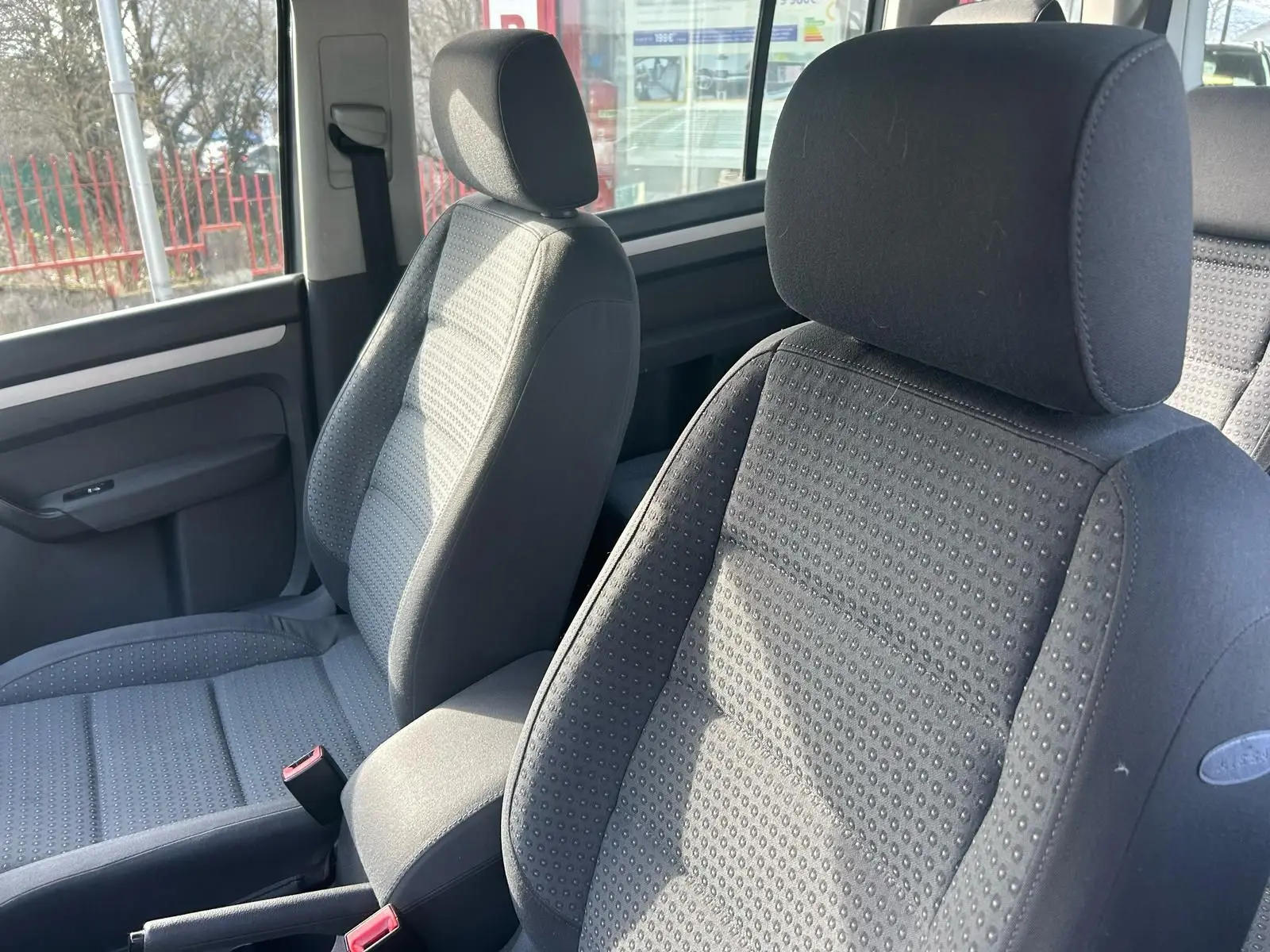 Gros plan sur les sièges avant gris du Volkswagen Touran 2004, montrant le tissu texturé et l'appuie-tête.