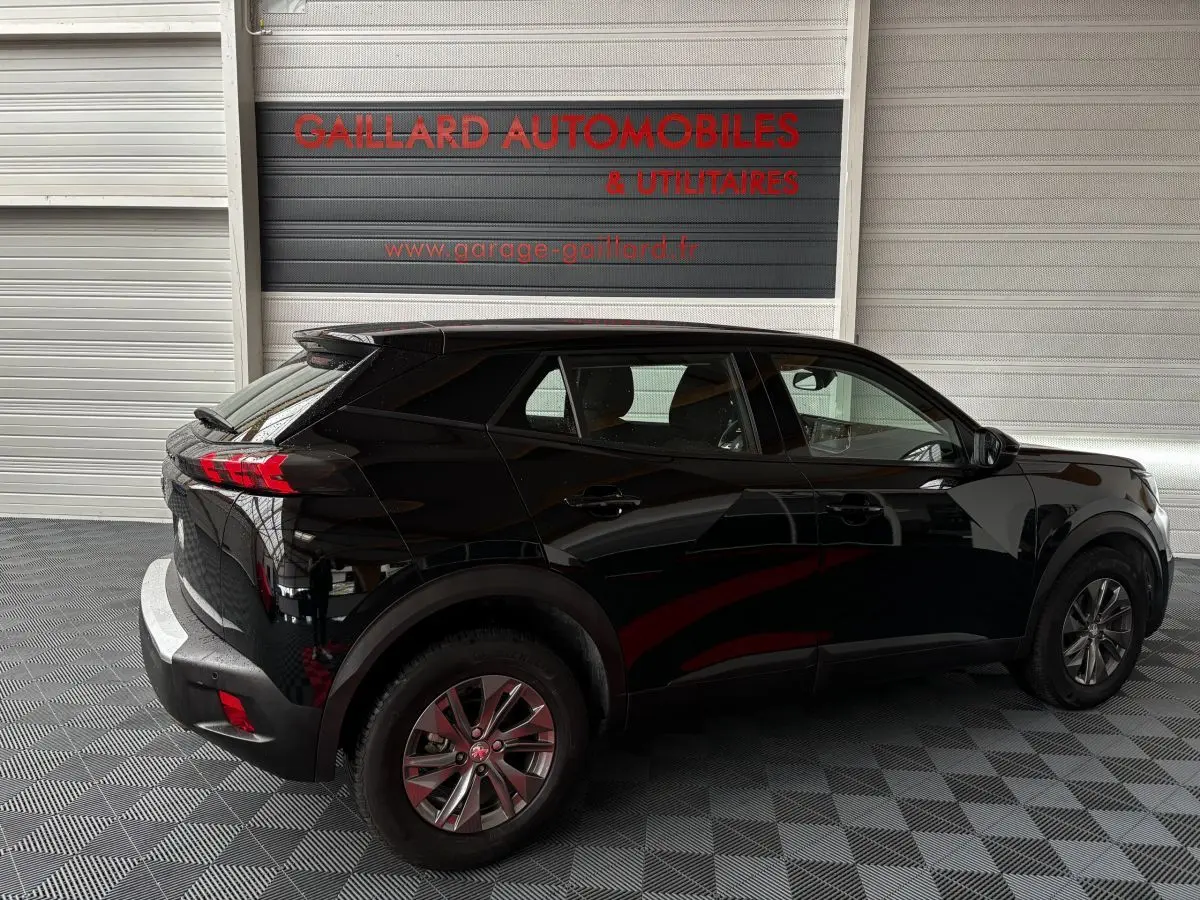 Peugeot 2008 noir vue de profil côté gauche dans un garage avec feux arrière LED et jantes alliage.