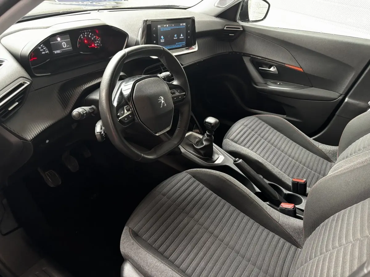 Intérieur avant droit du Peugeot 2008 noir 2021, volant cuir, tableau de bord numérique et écran tactile central visible.