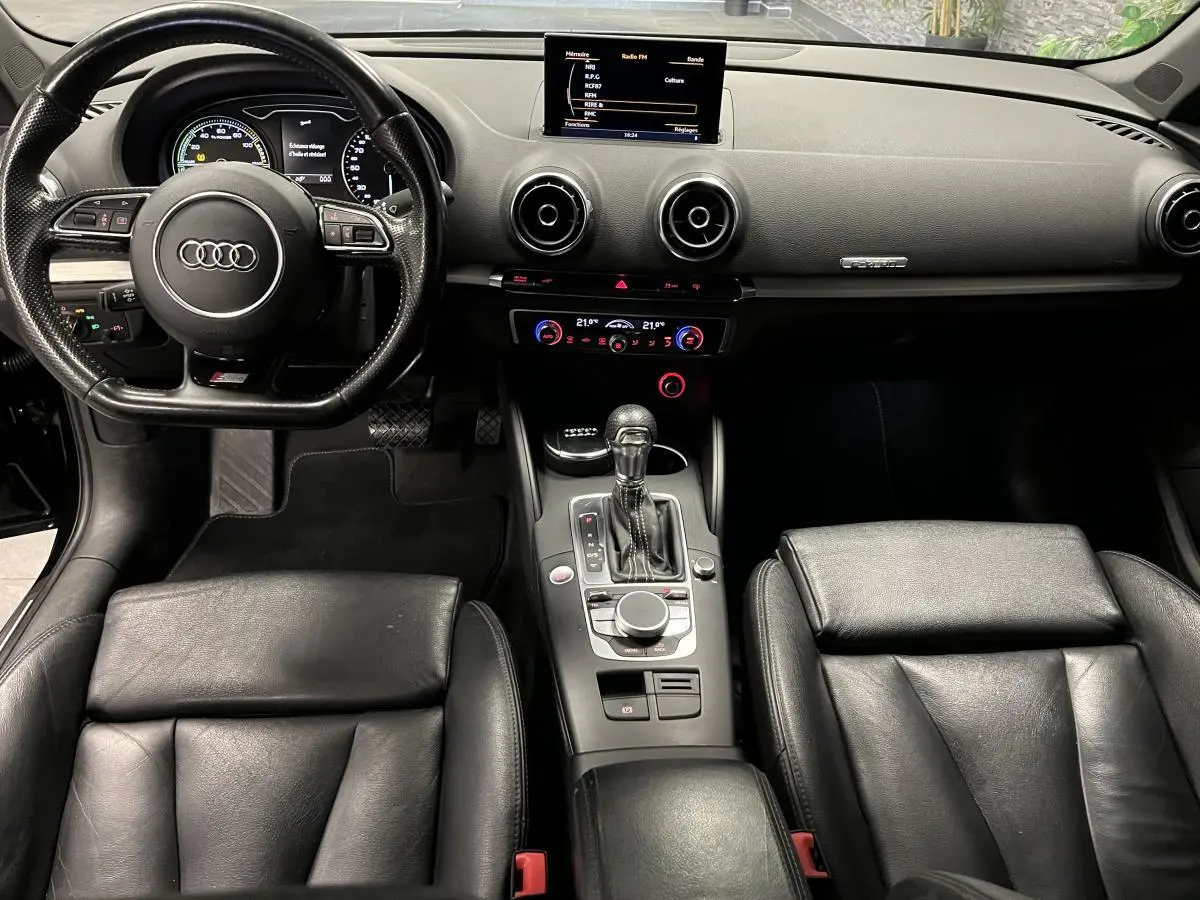 Intérieur noir cuir de l'Audi A3 1.4 TFSI e-tron S line 2015, vue centrale sur tableau de bord et volant sport.