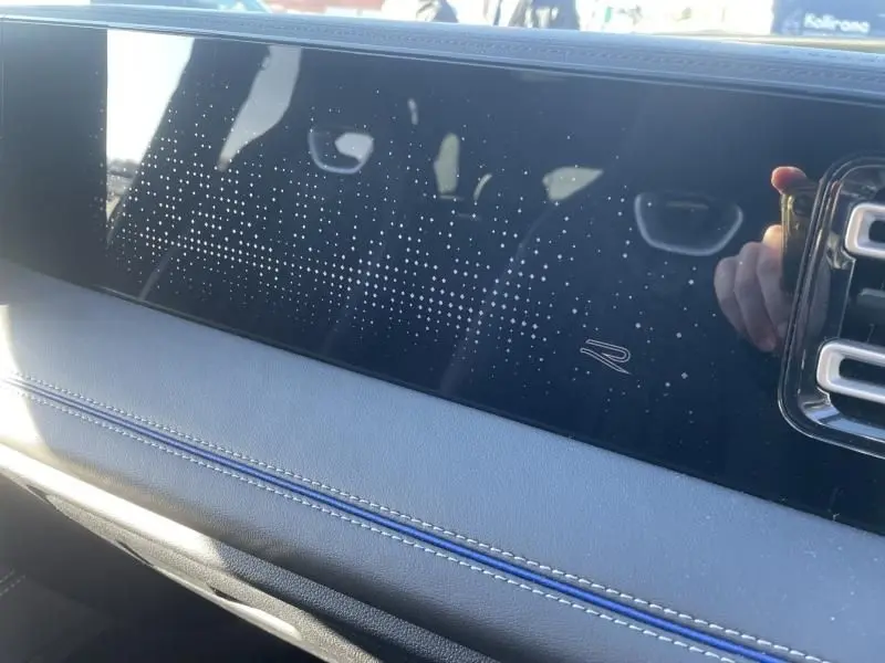 Détail intérieur du tableau de bord du Volkswagen Tiguan 1.5 eHybrid 2025, finition R-line avec motif étoilé et surpiqûres bleues.