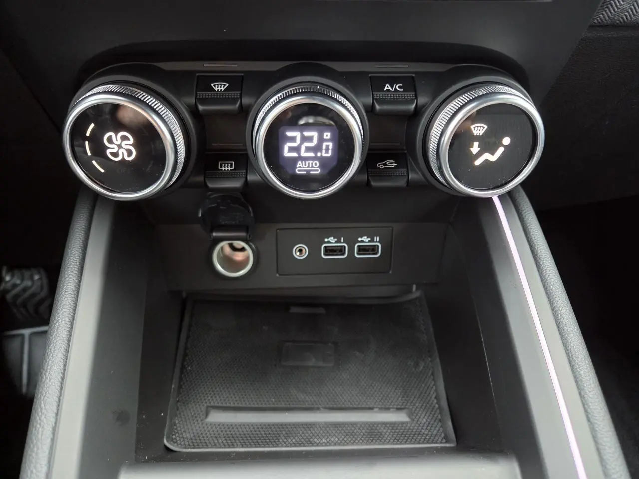 Vue rapprochée de la console centrale de la Renault Clio 2025 avec commandes de climatisation et ports USB.