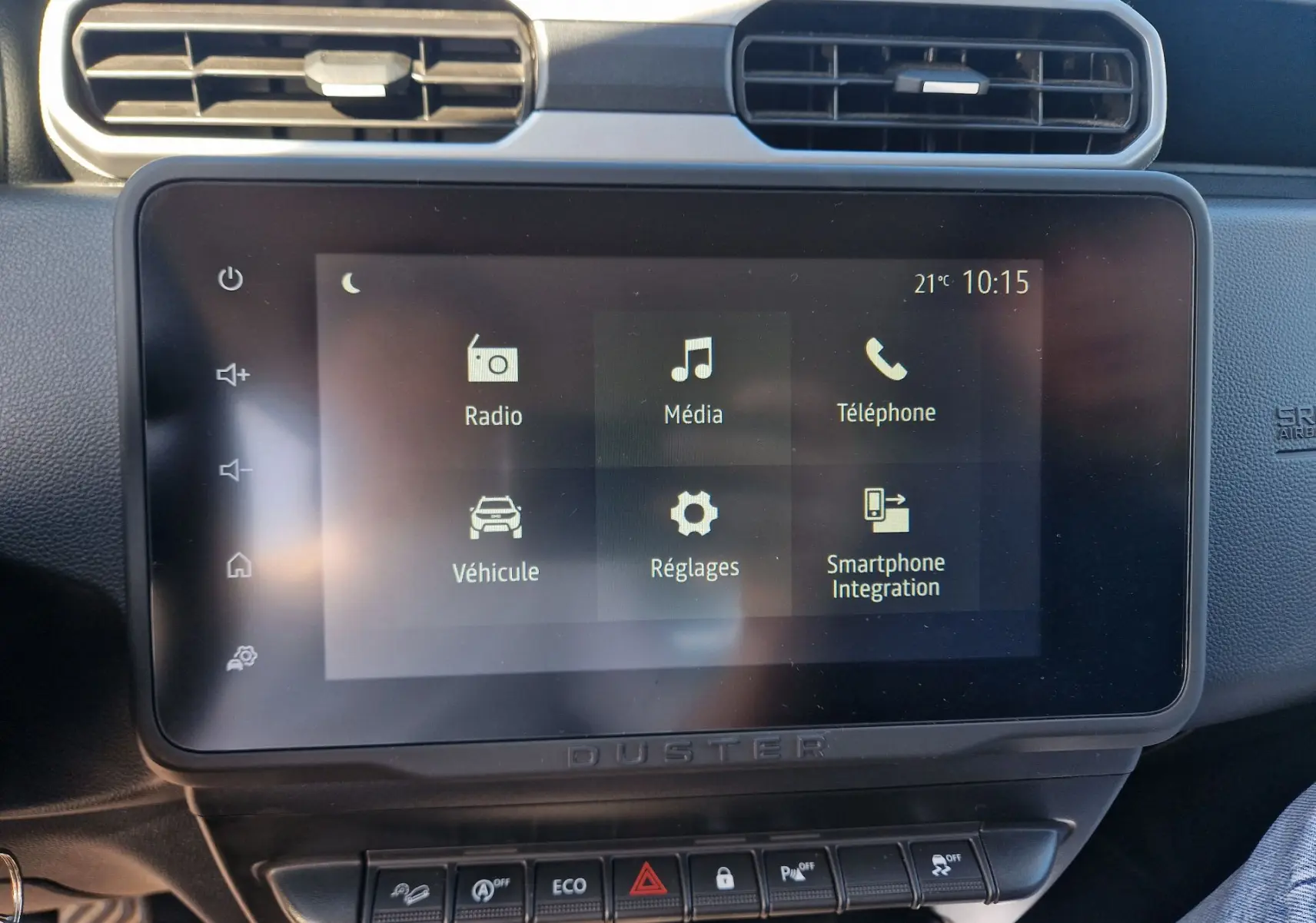 Vue rapprochée de l’écran tactile central du Dacia Duster 2024 avec interface multimédia et commandes sous l’écran.