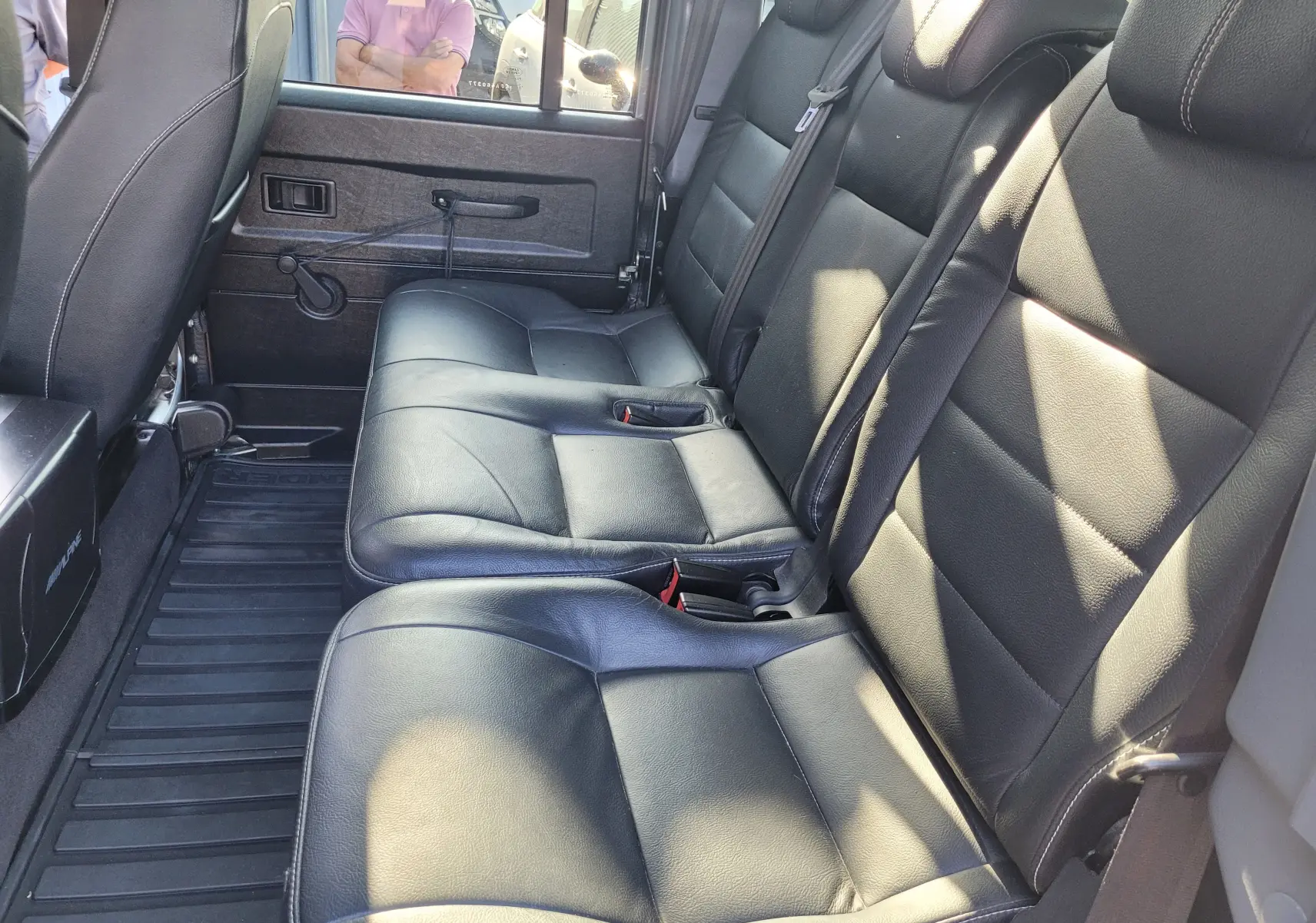 Vue intérieure côté droit des sièges arrière en cuir noir du Land Rover 110 Defender Edition Limiter gris de 2015.