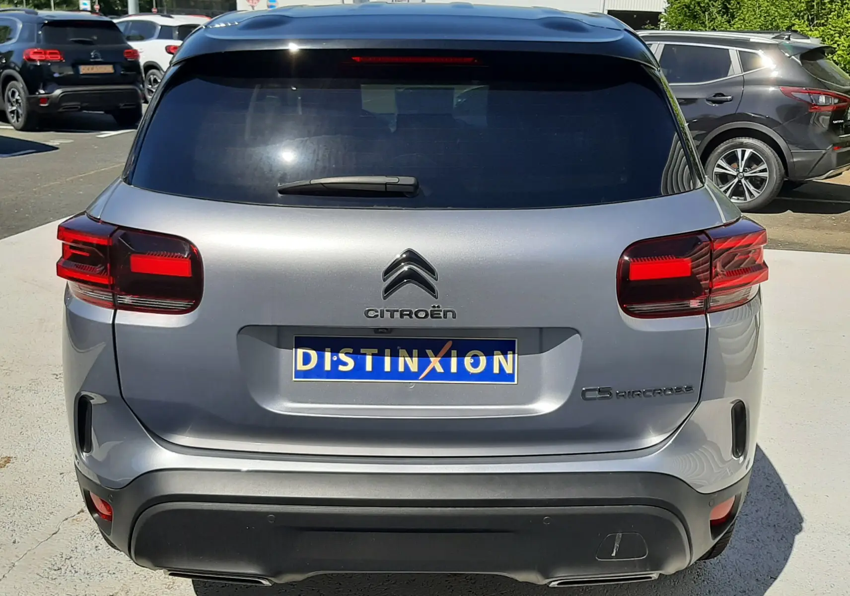 Vue arrière d'un Citroën C5 Aircross Hybrid 136 gris acier avec toit noir, feux arrière LED et plaque Distinxion.