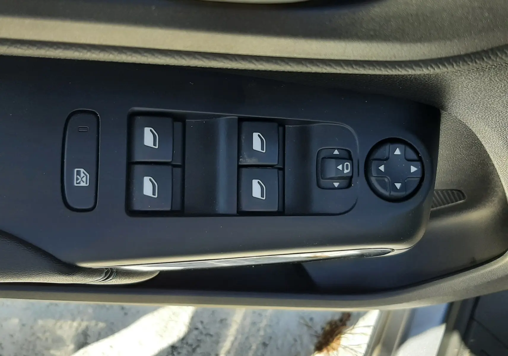 Gros plan sur les commandes de lève-vitres et réglage des rétroviseurs côté conducteur d'une Citroën C5 Aircross gris acier 2024.