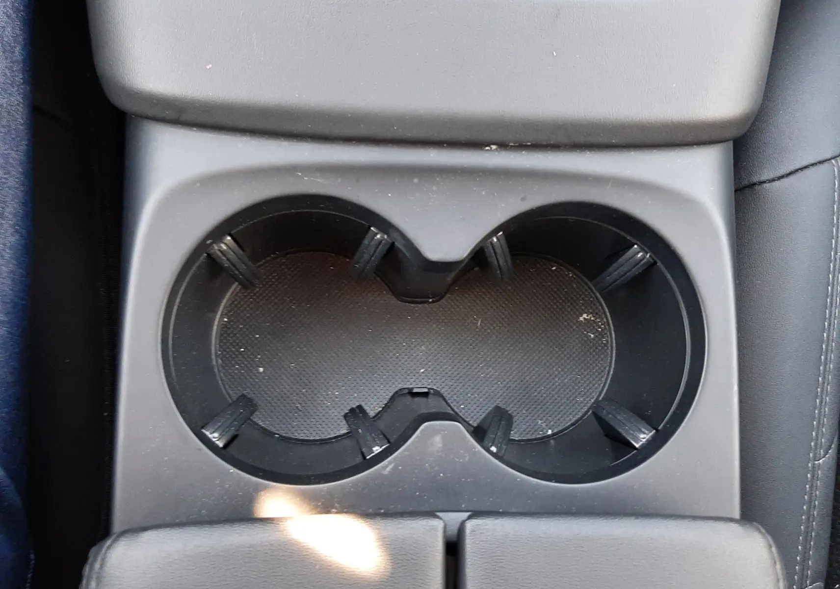 Gros plan sur les porte-gobelets noirs au centre de la console intérieure d'une Citroën C5 Aircross Hybrid 2024.