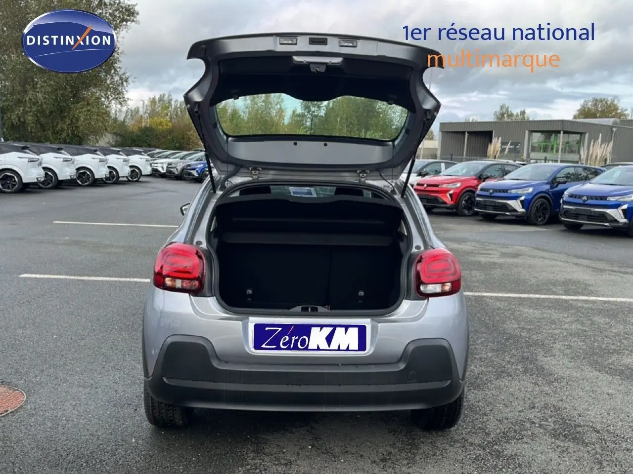 Vue arrière d'une Citroën C3 1.2 PureTech 82ch Plus gris Artense métal avec coffre ouvert sur un parking extérieur.