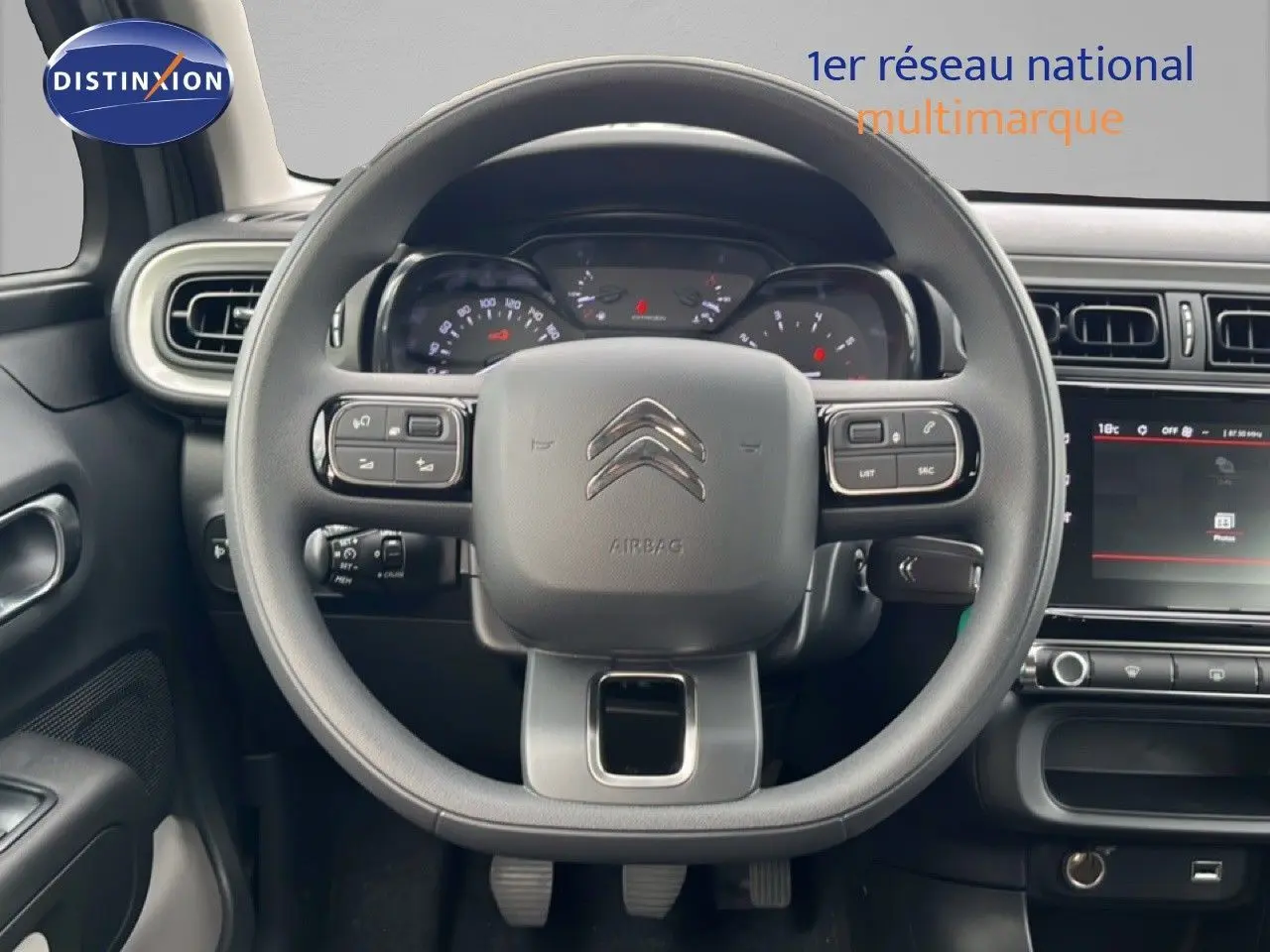 Vue centrée sur le volant et le tableau de bord de la Citroën C3 2024, intérieur gris avec écran tactile visible.
