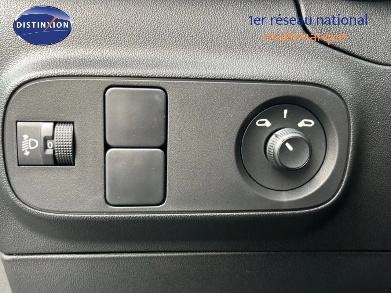 Détail des commandes de réglage des phares et des rétroviseurs dans l’habitacle d’une Citroën C3 gris Artense 2024.