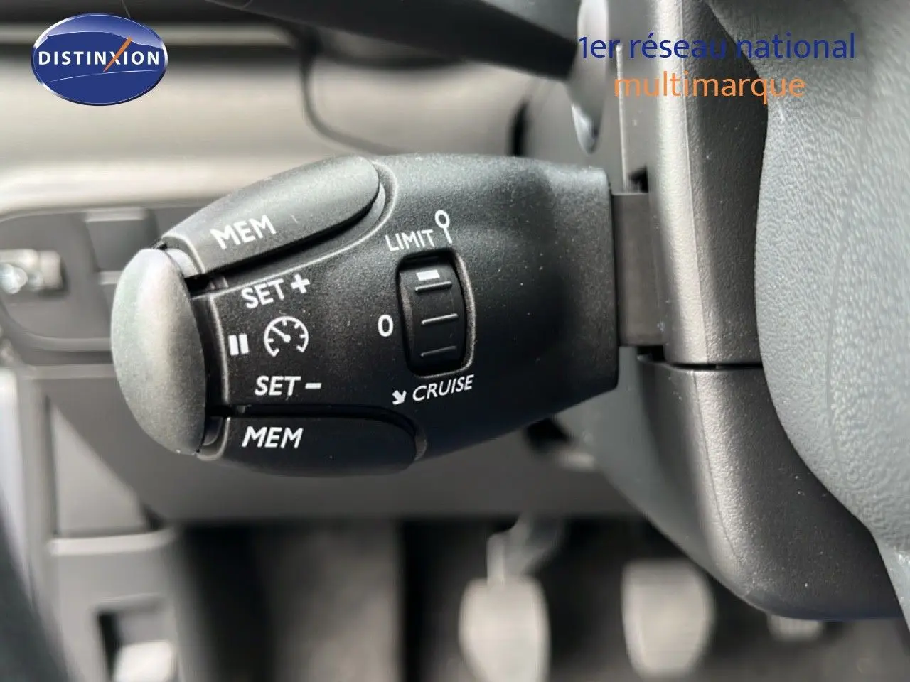 Gros plan sur la commande de régulateur de vitesse à gauche du volant d’une Citroën C3 gris Artense 2024.