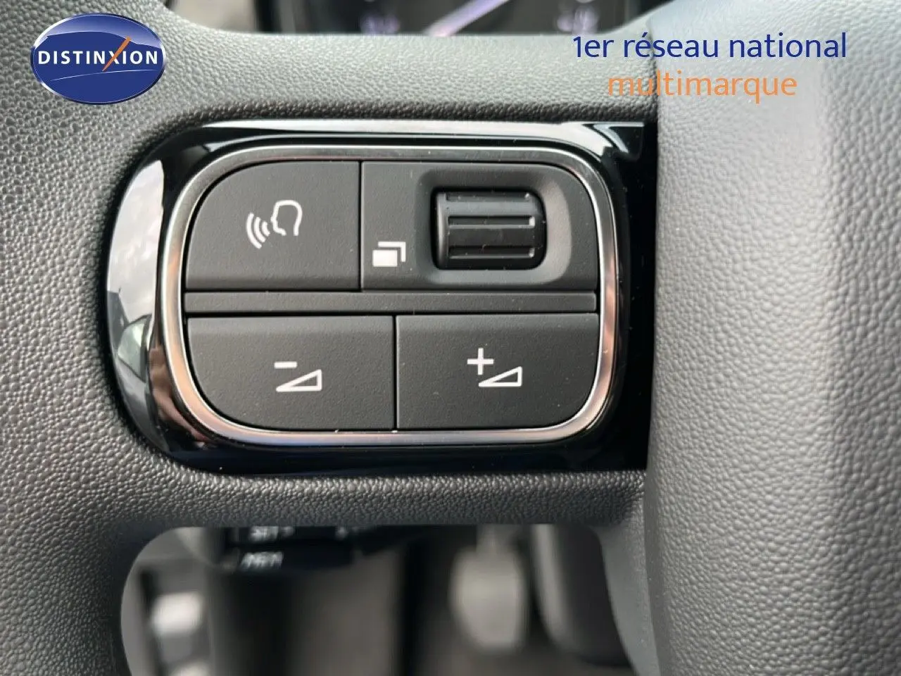 Gros plan sur les commandes de volume et téléphone intégrées au volant du Citroën C3 gris Artense métal 2024.