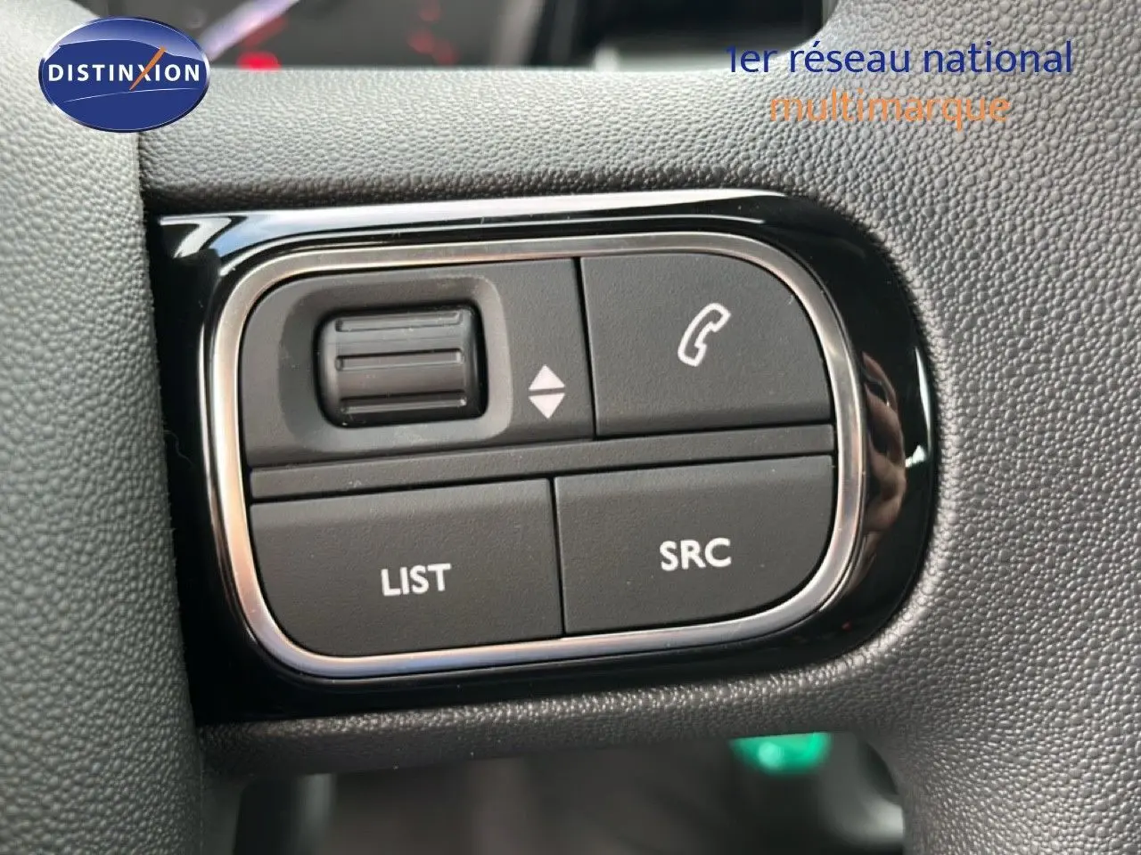 Gros plan sur les commandes au volant du Citroën C3 1.2 PureTech 82ch Plus, finition tissu gris/noir, 2024.