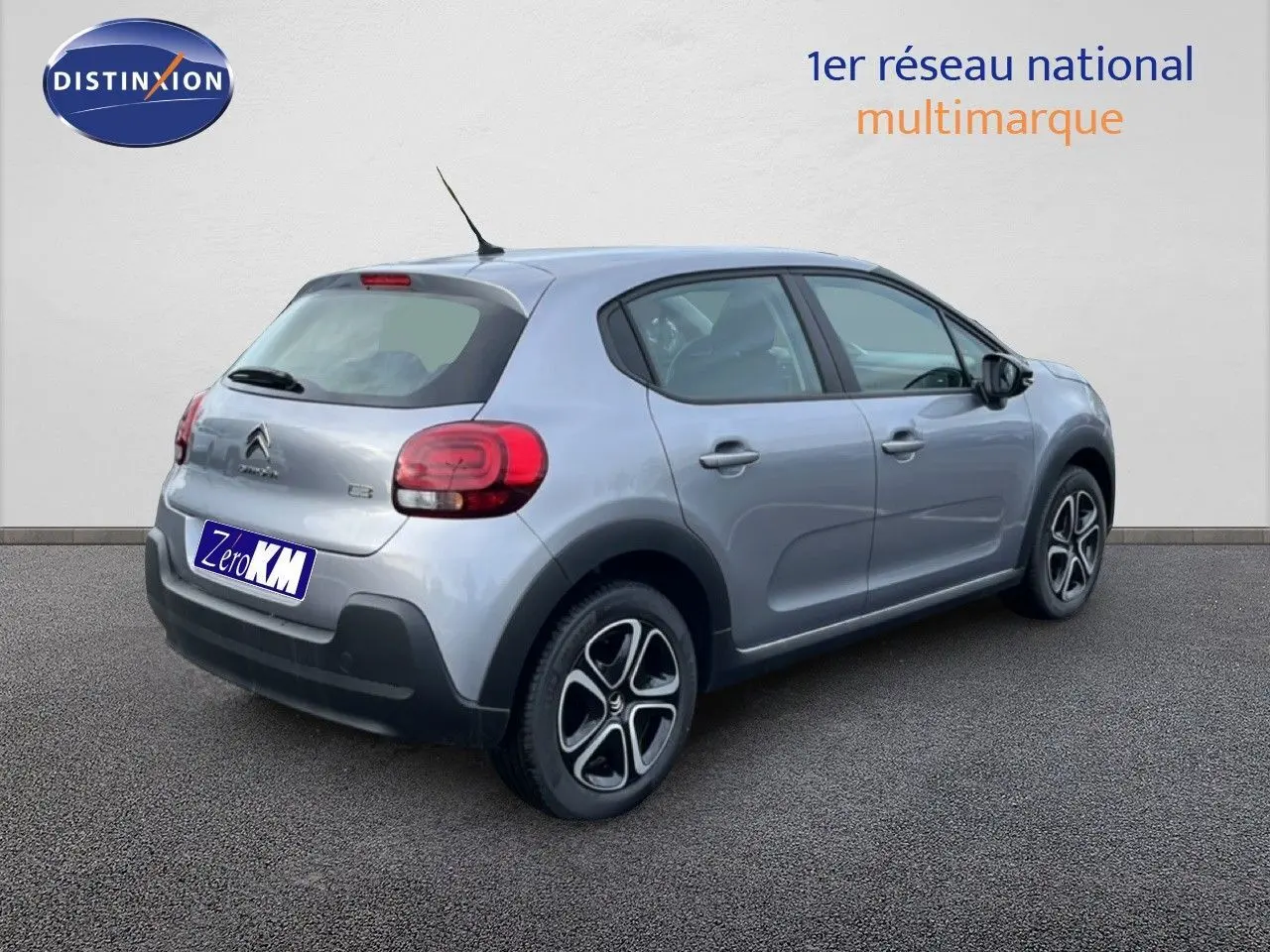 Vue 3/4 arrière droite d'une Citroën C3 2024 gris Artense métal avec feux arrière arrondis et jantes noires.