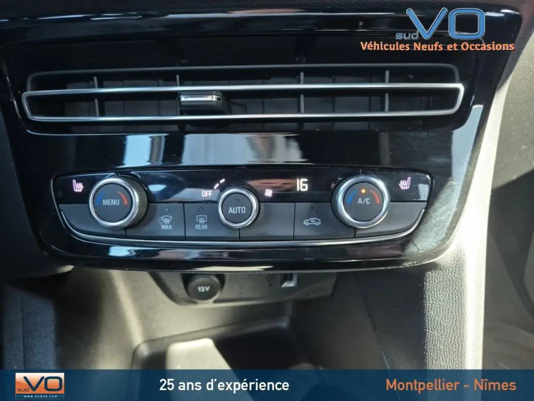 Vue rapprochée de la console de climatisation automatique de l'Opel Mokka gris clair avec commandes tactiles et affichage digital.