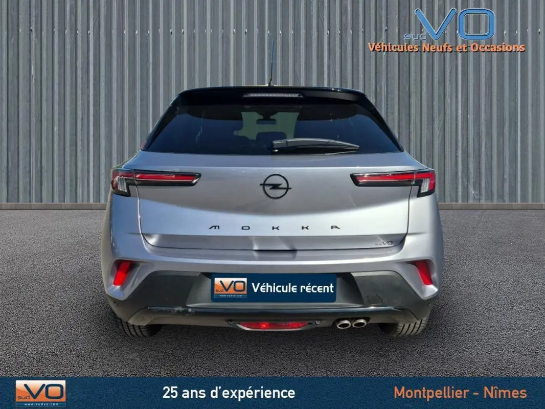 Vue arrière d'un Opel Mokka gris clair 2022 avec feux LED et double sortie d'échappement visible.