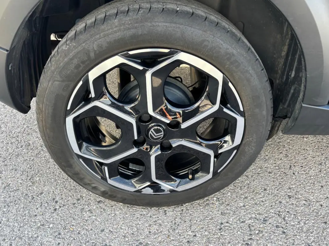 Gros plan sur la jante alliage 17 pouces noire et argentée de la Citroën C3 Turbo 100 ch, avec pneu monté.