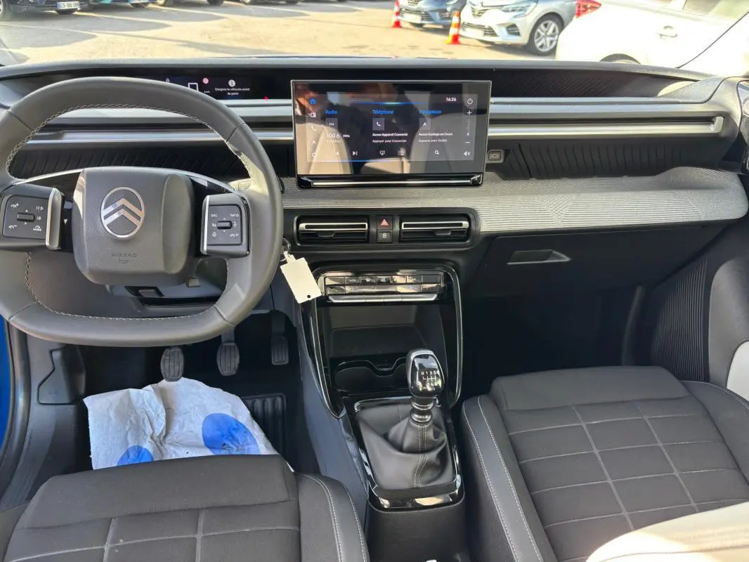 Vue intérieure avant du tableau de bord et volant de la Citroën C3 2025 avec boîte manuelle et écran tactile central.