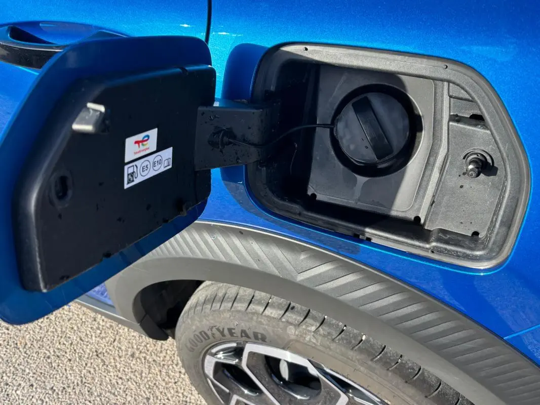 Gros plan sur la trappe à carburant ouverte côté gauche d’une Citroën C3 bleu 2025 avec jante alliage 17 pouces visible.
