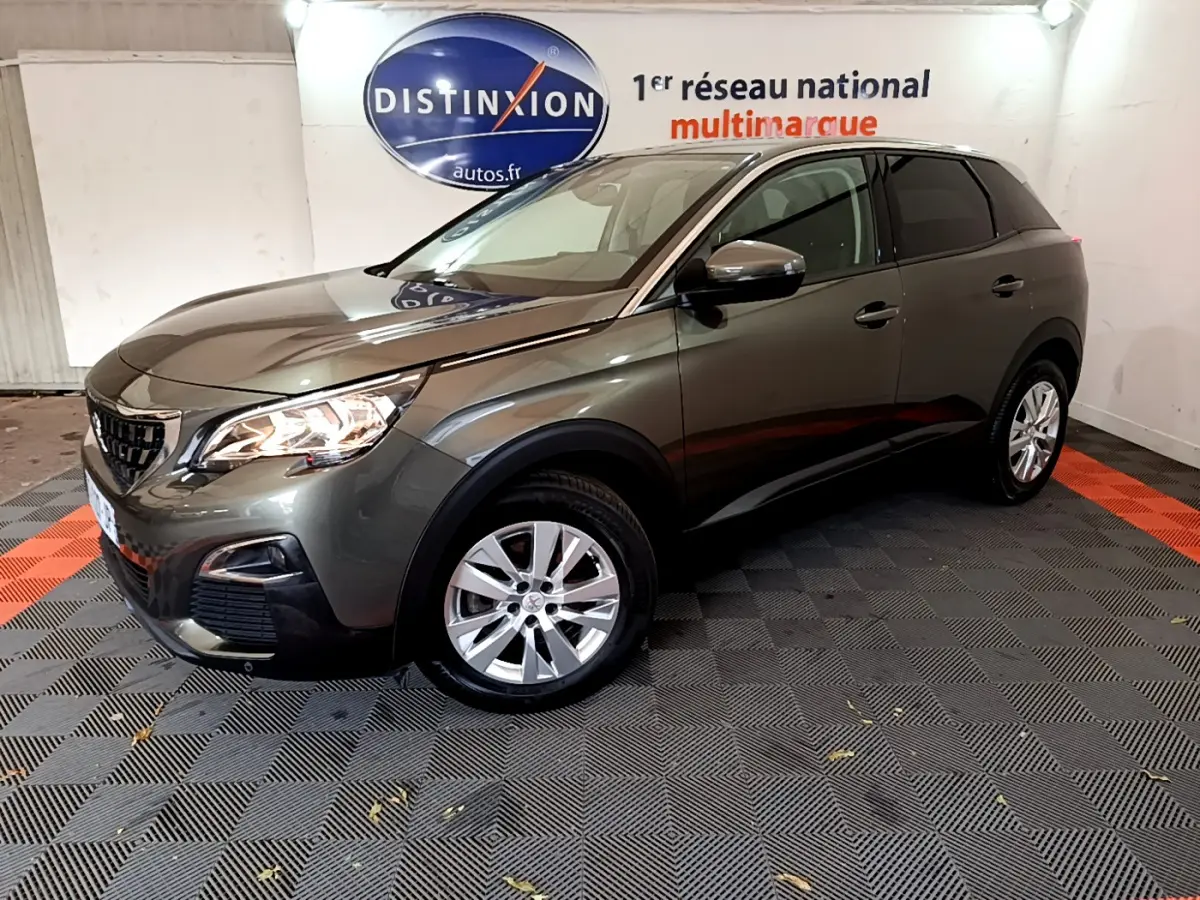 Peugeot 3008 gris foncé vue 3/4 avant droit, avec phares allumés et jantes alliage en showroom.