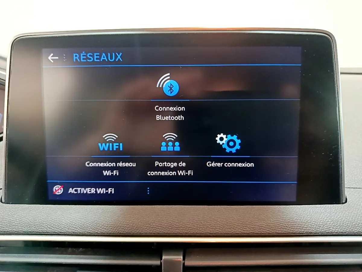 Écran tactile central du Peugeot 3008 2020 affichant les options de connexion Bluetooth et Wi-Fi sur un tableau de bord gris foncé.
