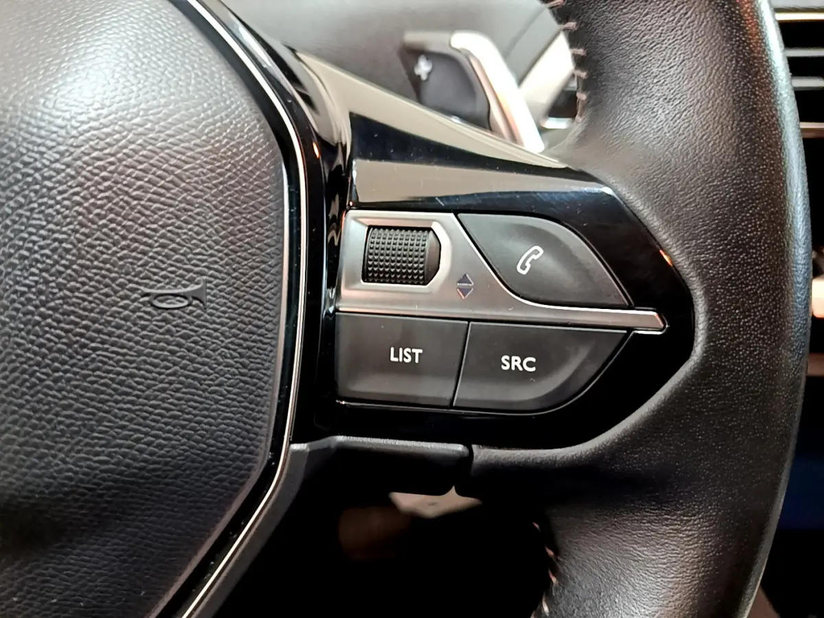 Gros plan sur les commandes droite du volant cuir du Peugeot 3008 gris foncé, boutons appel et audio visibles.