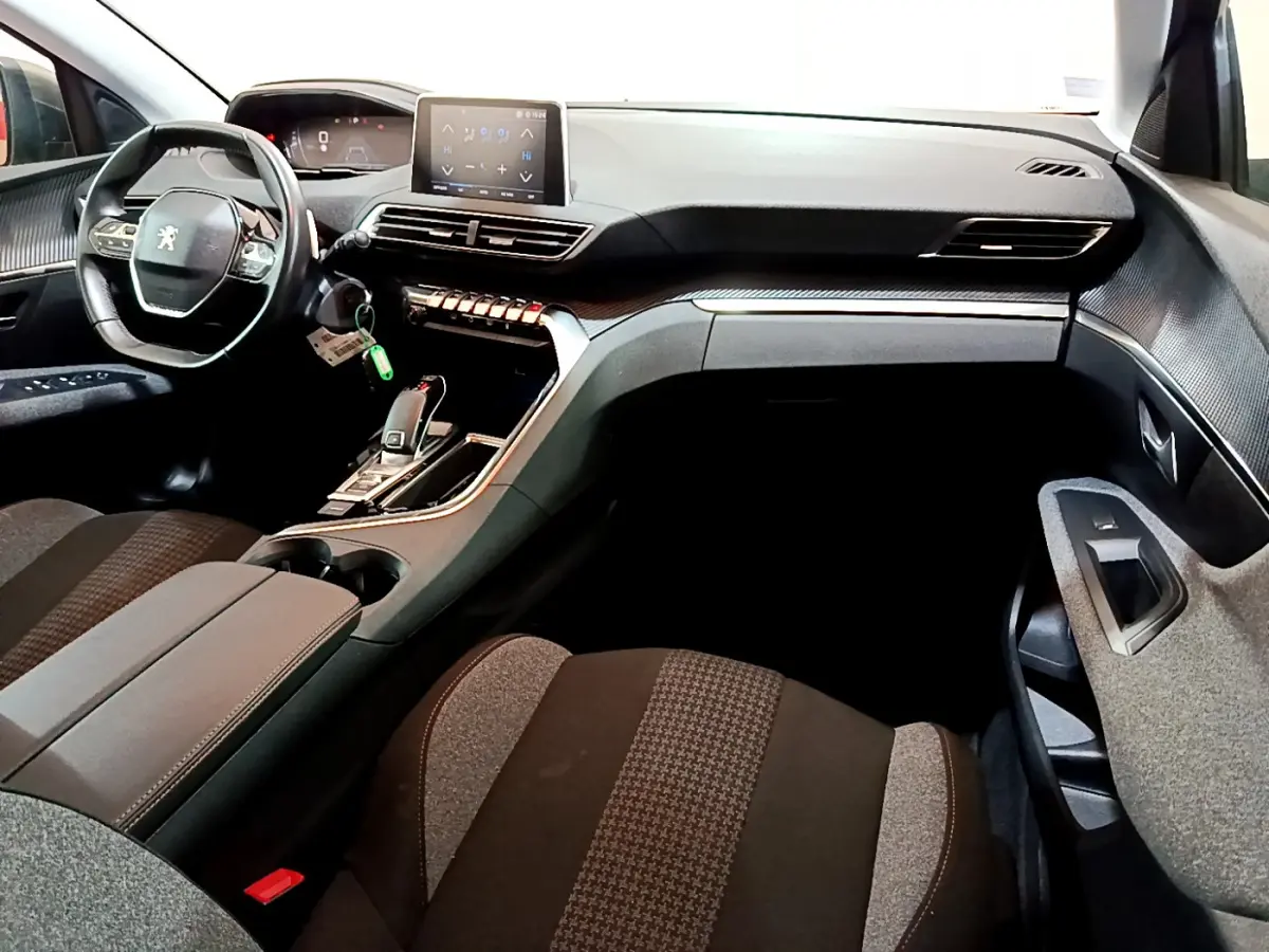 Intérieur du Peugeot 3008 2020 vu côté passager, tableau de bord noir avec écran tactile et volant cuir.