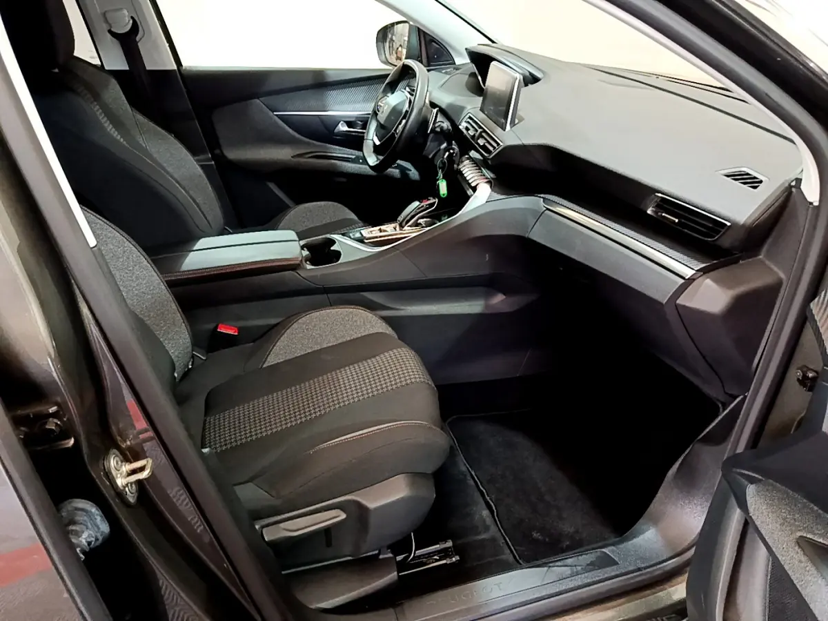 Intérieur avant droit du Peugeot 3008 gris foncé 2020, avec tableau de bord moderne et écran tactile central visible.