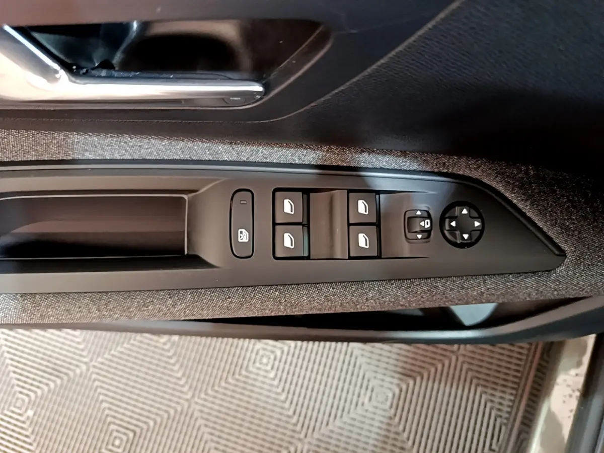 Panneau de commandes des vitres et rétroviseurs côté conducteur du Peugeot 3008 gris foncé, intérieur tissu.