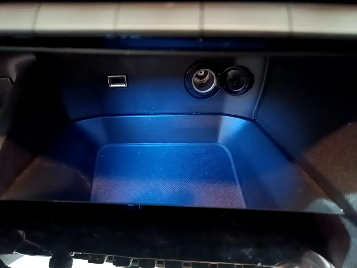 Rangement intérieur éclairé en bleu avec prise USB et prise 12V dans le Peugeot 3008 gris foncé 2020.