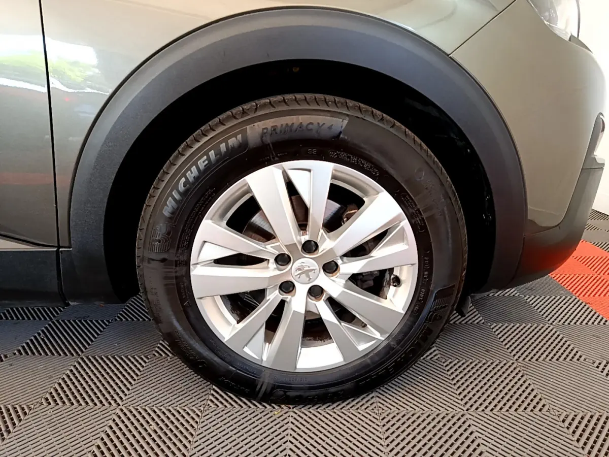 Gros plan sur la roue avant droite gris foncé du Peugeot 3008 avec jante argentée et pneu Michelin Primacy 4.