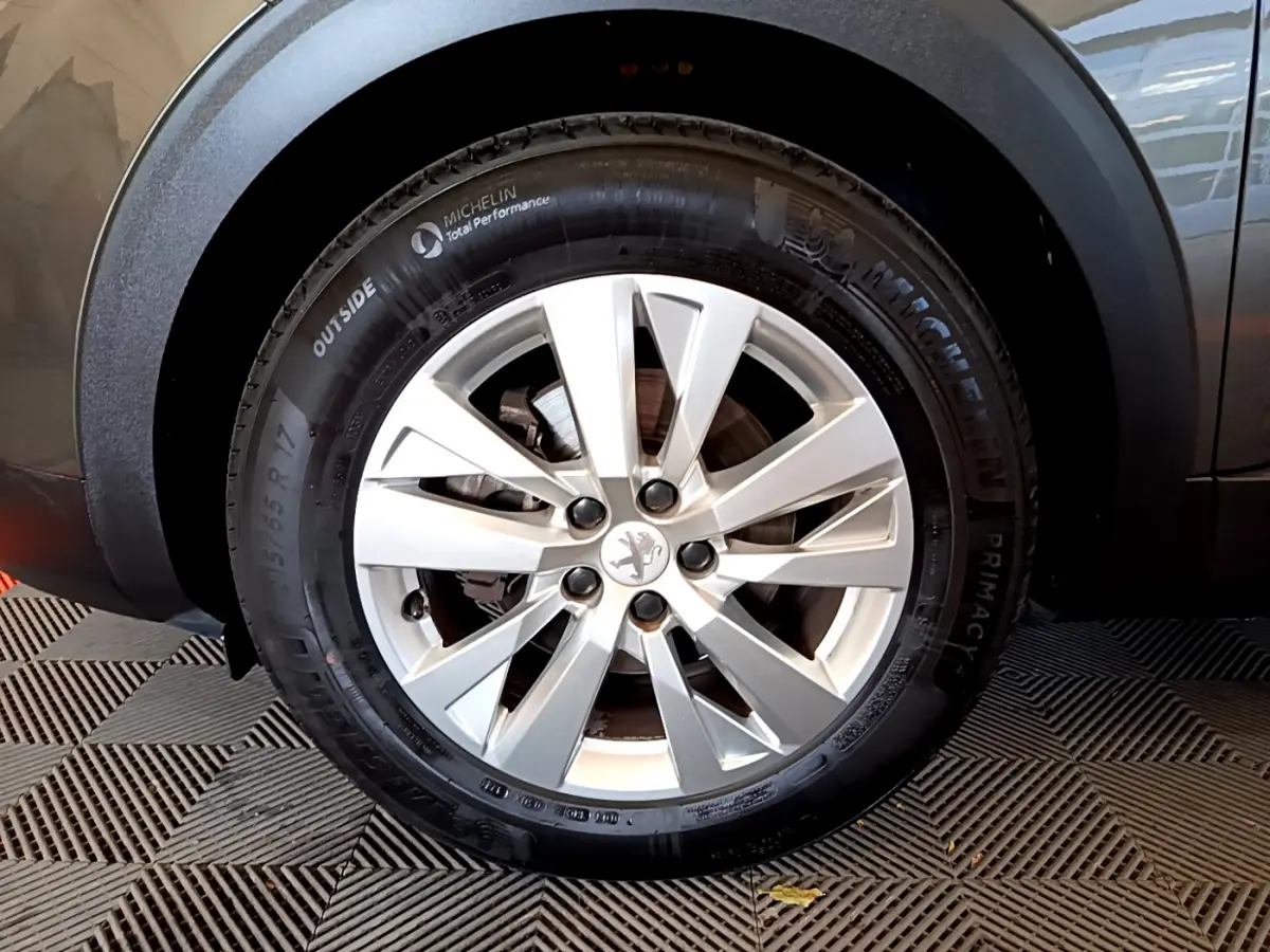 Gros plan sur la roue avant droite du Peugeot 3008 gris foncé, avec jante alliage et pneu Michelin.