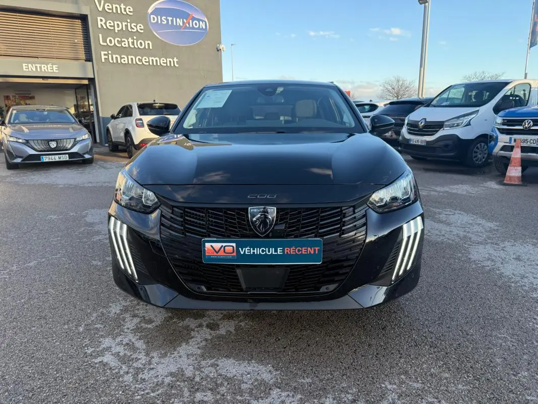 Vue de face d'une Peugeot 208 Hybrid 110 noire, avec ses phares LED distinctifs et la calandre noire brillante.